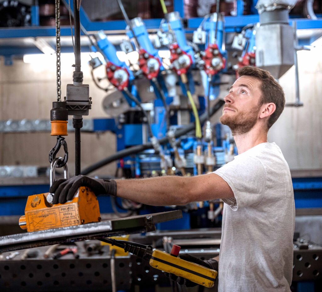 Ein Mitarbeiter aus dem Bereich der Qualitätskontrolle, der für das Fotoshooting des Industrieunternehmens posiert.