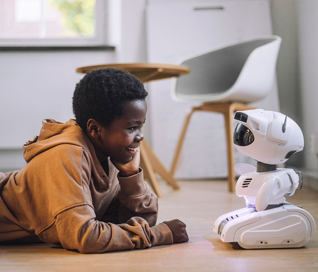 A little boy playing with a robot and used as a visual in the campaign on artificial intelligence that we implemented for our client as a creative agency.